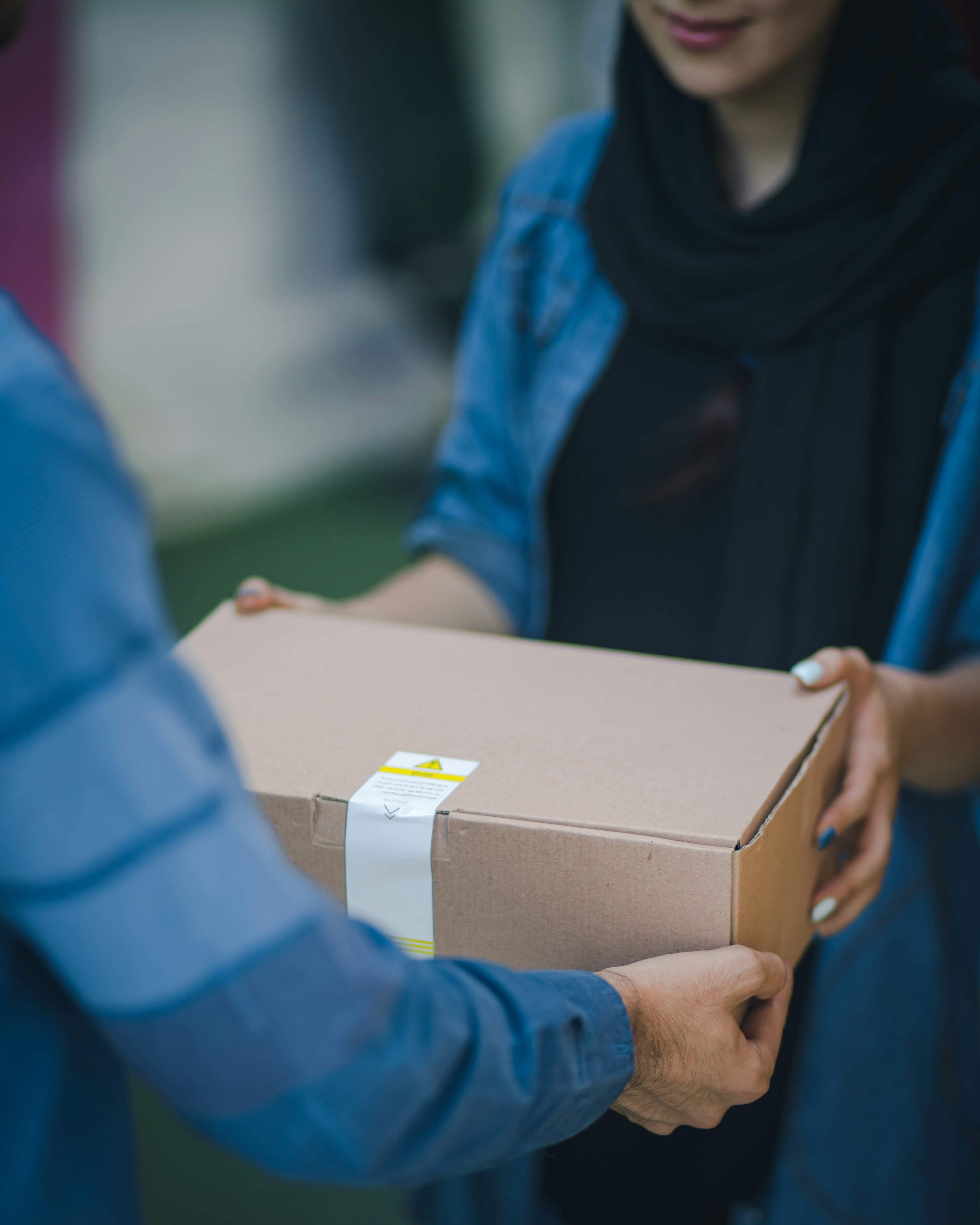 A returned package being handed off between two people at the door